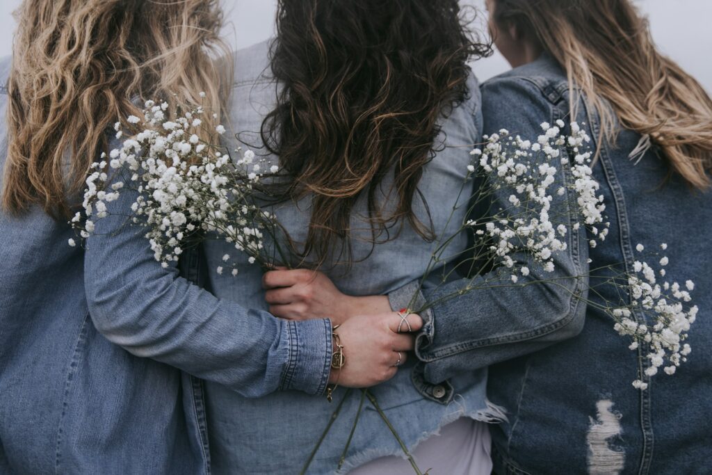 Tre donne che si abbracciano con affetto, simbolo di empatia, sostegno emotivo e della forza invisibile della connessione femminile — a rappresentare il tema del conforto e della trasformazione nelle relazioni.