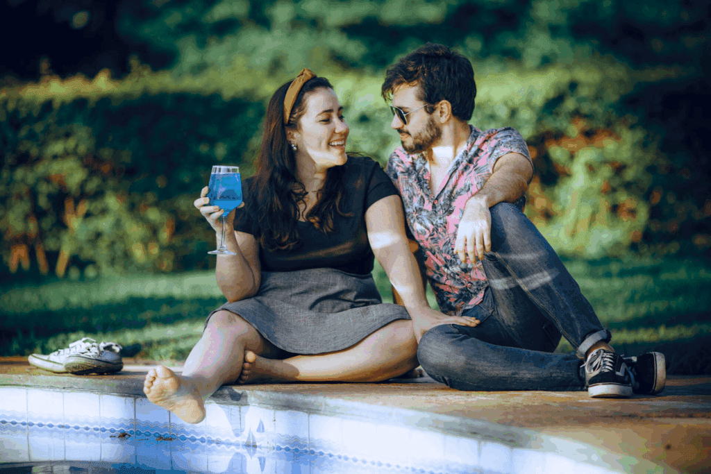 Una donna e un uomo seduti all’aperto condividono un momento rilassato e intimo, simbolo di come la fame emotiva e il rapporto emotivo con il cibo siano legati al bisogno di connessione e conforto.